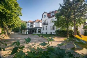 un gran edificio blanco al lado de una calle en Vital Resort Mühl en Bad Lauterberg