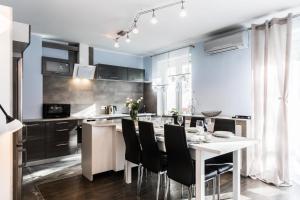a kitchen with a white table and black chairs at Apartament Sarnia Skała in Zakopane