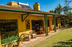 a yellow house with a green roof at Jacana Gardens in Harare