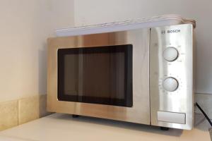 a microwave oven sitting on top of a counter at Stylish and homely space with considered work area in Norwich