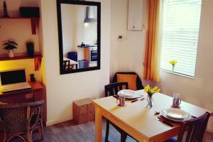 a dining room with a table and a mirror at Stylish and homely space with considered work area in Norwich