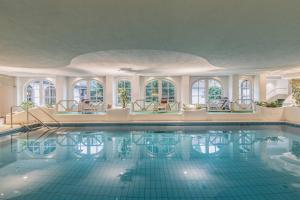 an indoor swimming pool with windows and a ceiling at Mühl Vital Resort in Bad Lauterberg