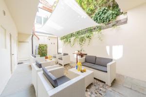 a living room with white furniture and a skylight at trifulhouse holiday apartments in Alba
