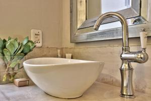 a white bowl sink in a bathroom with a faucet at The Beach Loft in Hout Bay