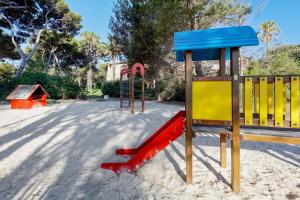 een speeltuin met een glijbaan in het zand bij Résidence Pierre & Vacances La Pinède in Hyères