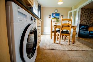 a kitchen with a washing machine and a dining room at Modern three bedroom house in Bundoran - Bundoran Luxury Apartments and Holiday Homes in Bundoran