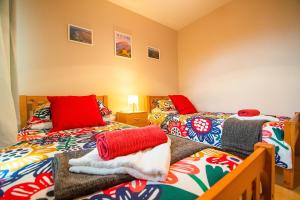 a room with two beds with blankets and pillows at Modern three bedroom house in Bundoran - Bundoran Luxury Apartments and Holiday Homes in Bundoran