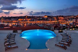 a swimming pool on the roof of a building with chairs at The Yeatman in Vila Nova de Gaia