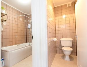 un baño con inodoro y bañera en Three Beaches Holiday Apartments - close to Goodrington beach in Paignton, en Paignton 18 fotos más