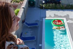 een jonge vrouw op zoek naar een water spel bij Terraces d'Orlando - Family Apartments with Sea View and Pool in Capo dʼOrlando