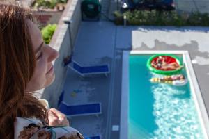 una joven mirando un juego de agua en Terraces d'Orlando - Family Apartments with Sea View and Pool, en Capo dʼOrlando