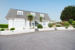una casa blanca con una entrada delante de ella en Three Beaches Holiday Apartments - close to Goodrington beach in Paignton, en Paignton