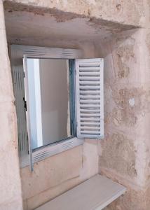 una finestra con una panca in un muro di pietra di CasAntonia - Locazione Turistica a Polignano a Mare