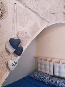 una camera da letto con due cuori appesi a un muro di CasAntonia - Locazione Turistica a Polignano a Mare