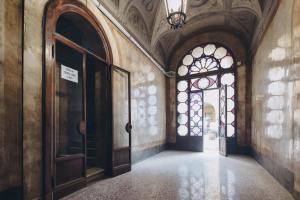 un pasillo vacío con una puerta y una ventana en Gregorini Bingham Art Luxury Suites, en Bolonia