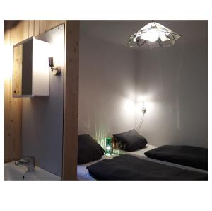 メッケンベウーレンにあるGästezimmer Wagnerのベッドルーム1室(ベッド2台、鏡、照明付)