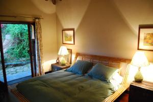 1 dormitorio con 1 cama con 2 lámparas y una ventana en Casa Dos Canais, River Cottage, en Marco de Canaveses