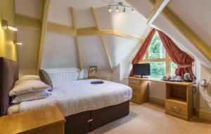 een slaapkamer met een bed, een bureau en een raam bij Windermere Park inc Free off-site Health Club in Windermere