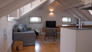 eine Küche und ein Wohnzimmer mit einem Sofa und einem Tisch in der Unterkunft APOSENTUS - Architect and design apartment in Porto