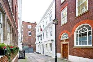 an alley with buildings and a street light next to a building at Eldon Chambers Pod 6 by City Living London in London