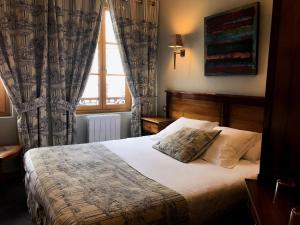 a bedroom with a bed and a window at Entre Terre Et Mer in Honfleur