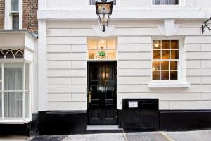 Eldon Chambers Pod 4 by City Living London في لندن: مبنى أبيض مع باب ونوافذ سوداء