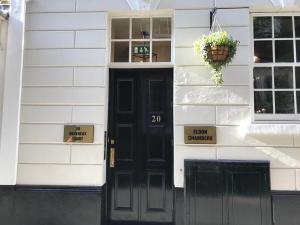 a black door on a white house with a window at Eldon Chambers Pod 3 by City Living London in London