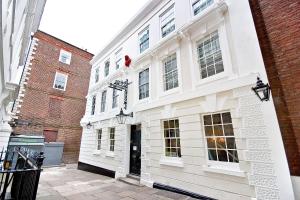 a white building with a black door on a street at Eldon Chambers Pod 3 by City Living London in London