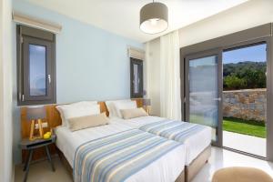 
a bedroom with a large bed and a large window at Apartment Tilio in Rethymno Town
