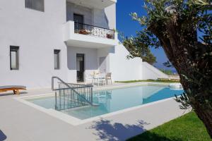 
a large white swimming pool sitting next to a building at Apartment Tilio in Rethymno Town
