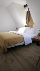 a bedroom with a large bed with white sheets at Willowa Chata in Dzianisz