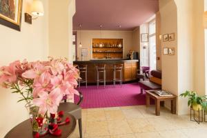 ラ・フレーシュにあるLogis Hôtel Le Vert Galantのリビングルーム(ピンクの花がテーブルに飾られた)