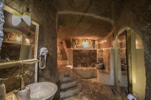 a bathroom with a sink and a tub and stairs at Heaven Cave House - Razziya Evi in Ürgüp