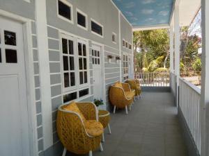 une terrasse couverte avec des chaises et des tables en osier dans l'établissement J-Rima Homestay Borong, à Wado