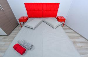 a bed with a red headboard and two red tables at City Center Suite With Terrace in Bucharest