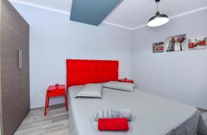 ein rotes Bett in einem weißen Zimmer mit rotem Kopfteil in der Unterkunft City Center Suite With Terrace in Bukarest