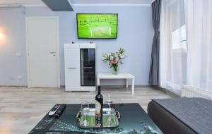 Sala de estar con mesa y botella de vino en City Center Suite With Terrace, en Bucarest