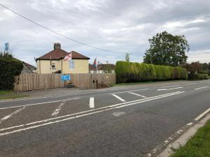 an empty street with a house and a fence at 1 Ashford Road Guesthouse in Redhill