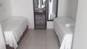 een slaapkamer met 2 bedden en een spiegel bij Pousada Boa Vida in Maceió