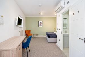 una camera con letto, scrivania e lavandino di Interlude House C by City Living London a Londra