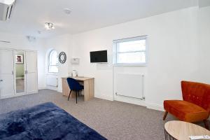 una camera con letto, scrivania e TV di Interlude House C by City Living London a Londra