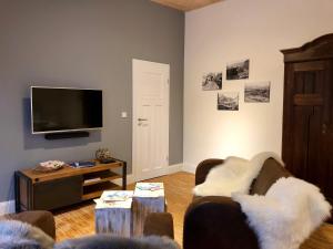 a living room with a couch and a tv at Heimatlodge in Sinsheim