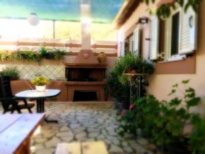 an outdoor patio with a fireplace and a table at TO PATRIKO - APARTMENTS FOR RENT in Igoumenitsa
