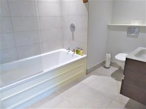 a white bathroom with a tub and a toilet at Town Hall Lofts, Settle in Settle