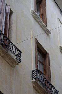 - un bâtiment avec deux fenêtres et un balcon dans l'établissement Hotel Concorde, à Nîmes