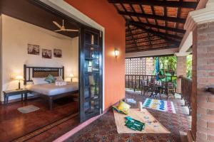 1 dormitorio con 1 cama y balcón en SaffronStays Blue Flag House, a 3-BDR beachfront villa in Hejamady, en Mangalore