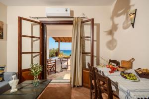 a dining room with a table and a view of the ocean at Theonis Villas Naxos 30 meters from the beach in Kanakis