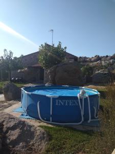 une grande baignoire bleue assise dans l'herbe dans l'établissement Entre las Piedras y musgo, à Muñopepe