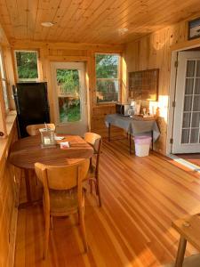 a dining room with a table and chairs in a cabin at Cobblescote on the Lake in Cooperstown