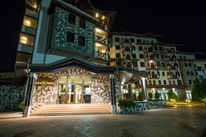 a building at night with a building at Rhodopi Home Hotel Chepelare - Half board in Chepelare